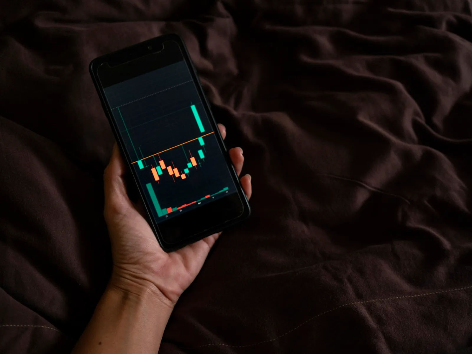 Trader consultant un graphique crypto dans une app de trading mobile